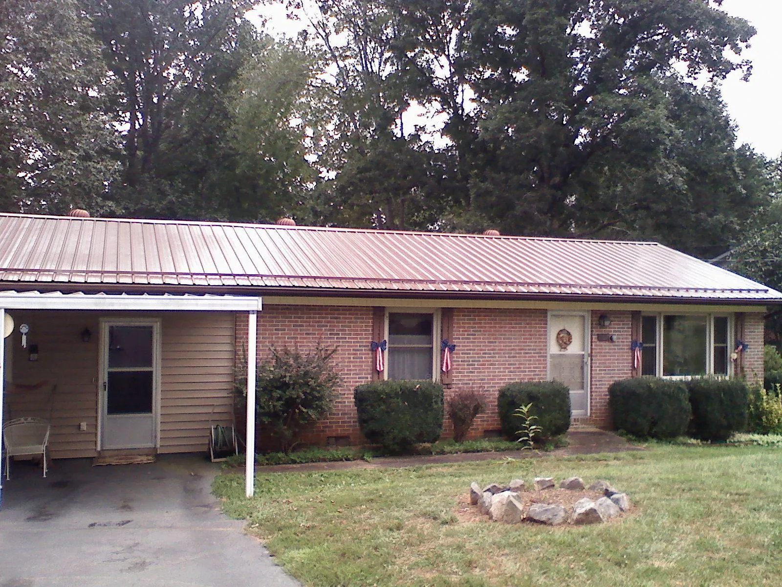 Bronze metal roof and carport on a brick ranch home — Roof Repair work by our crew in Simpsonville