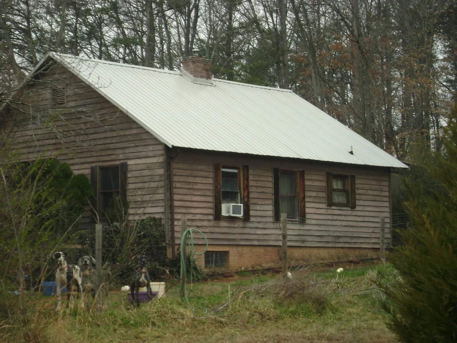 White metal roof on an old wood sided farmhouse, from a Metal Roof Installation job in Simpsonville
